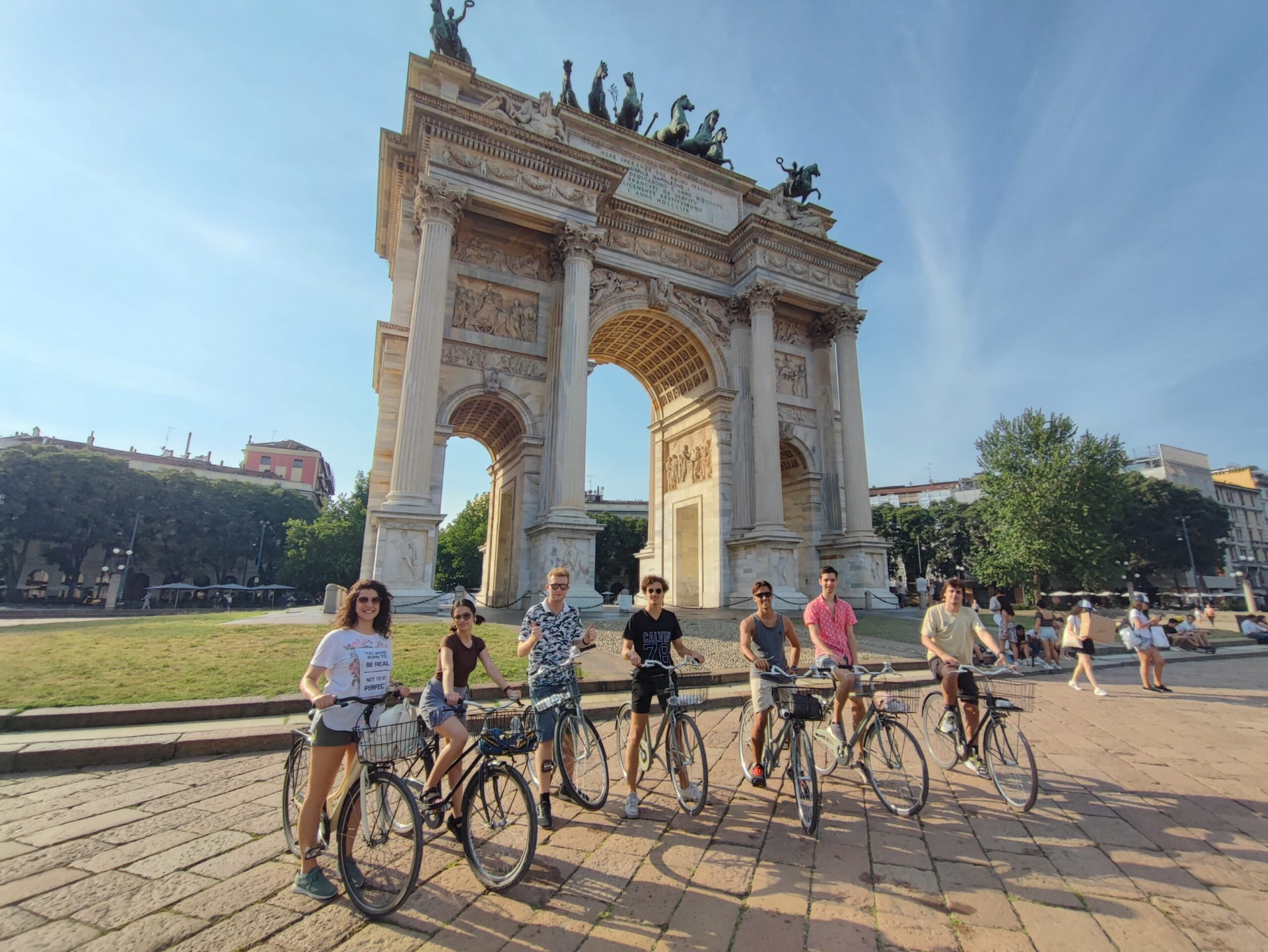 Students on bikes in front of the Arco della Pace, Milan